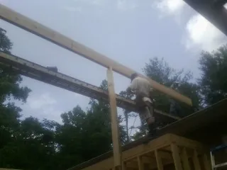 Carpenter setting a ridge beam over a new addition frame — Ice Dam Removal by Roofing Brothers in Ettrick